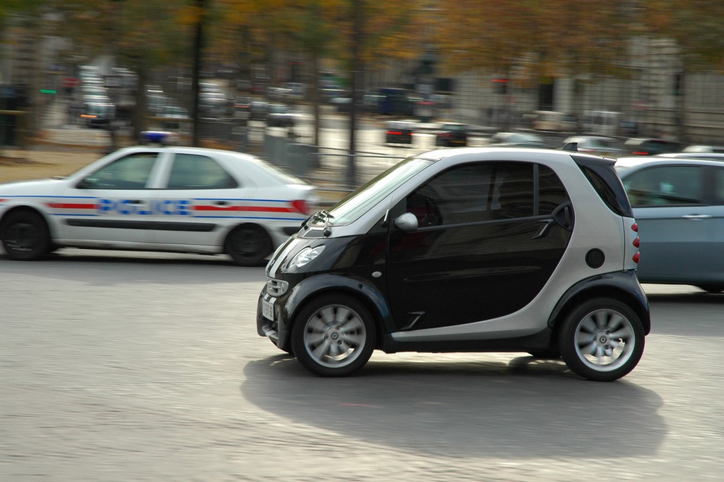 a silver and black Smart car driving on the road.jpg