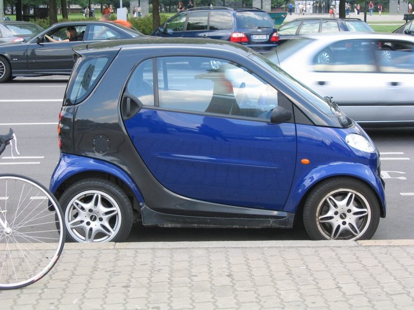 Navy blue Smart car on the road.jpg
