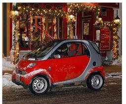 A grey and red Smart car cover with some snow.jpg